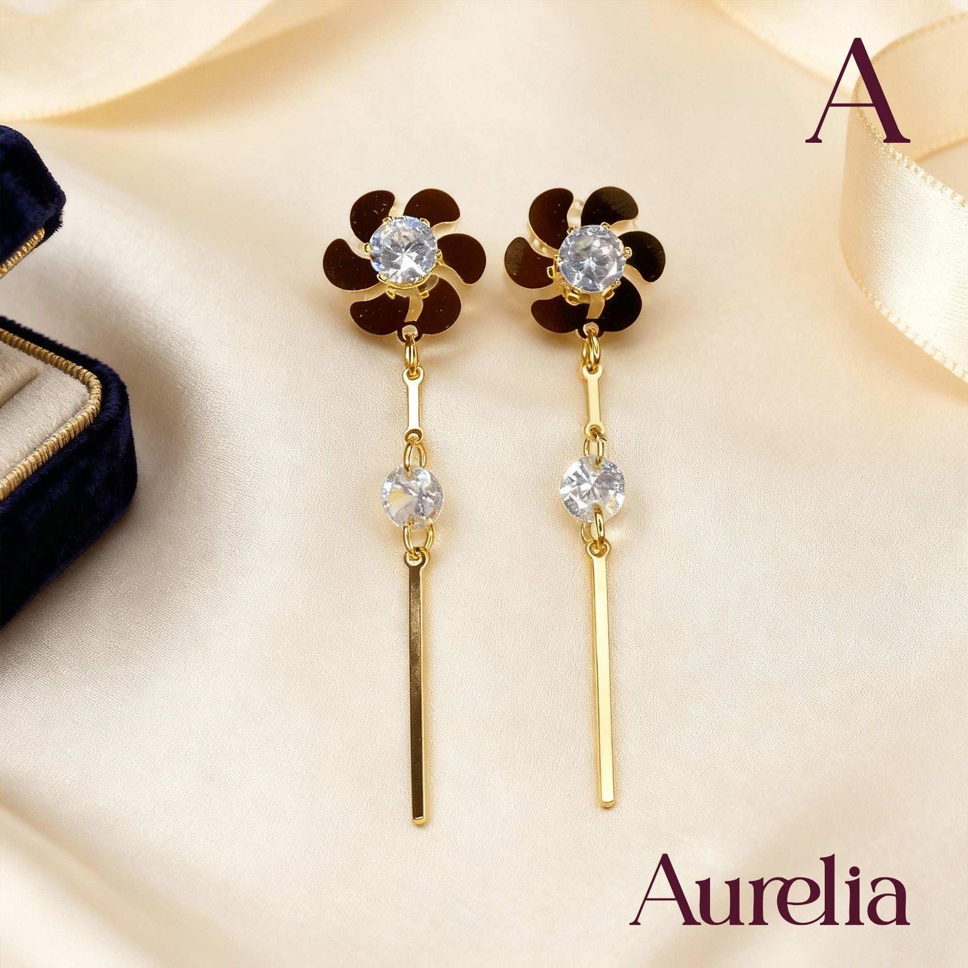 ARETES LARGOS FLOR Y PALO DETALLE PLATEADO